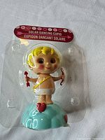 Front view of blister-packaged solar dancing cupid figurine