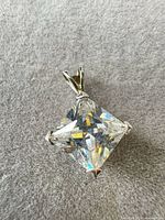 Front view of pendant showing princess-cut stone and setting