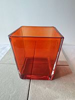 Front view of square orange glass vase