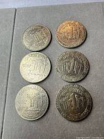 Front and back of six Mirage $1 gaming tokens
