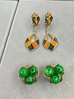 Both earring pairs displayed on grey background