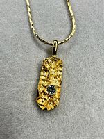 Full view of pendant on chain showing design and stone
