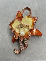 Full view of brooch front showing enamel colours, faux pearl, rhinestones and overall design