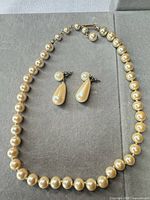 Full view of faux pearl necklace and earrings set