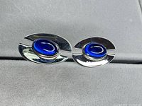 Front view showing blue cabochon set in silver-tone frames