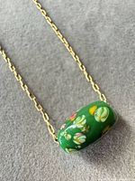 Green millefiori glass bead on gold-tone chain