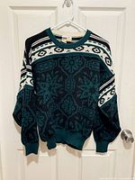 Full front view of wool jacquard sweater on hanger