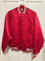 Front view of red satin varsity jacket hanging