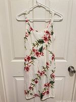 Full front view of sleeveless floral sundress on hanger