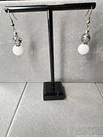 Front view of both earrings on stand