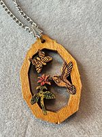 Close-up of wood pendant showing motifs and chain bail