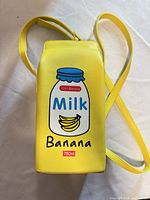 Front view of yellow Banana Milk carton crossbody bag with strap visible