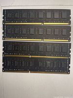 Four black DDR4 DIMMs, IC side visible