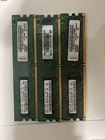 Six DDR2 UDIMM modules arranged on white surface, labels visible