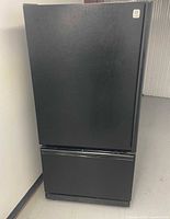 Front view of closed black GE refrigerator