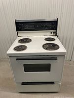 Front view of GE electric coil range with four burners and control panel