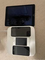 Front view showing iPad screen, three iPhones on top of Mac mini