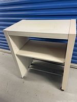 Front three-quarter view of desk showing overall design, wheels and shelf
