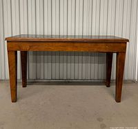 Front view of rectangular wood bench showing legs and overall form