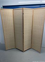 Front view of fully extended four-panel rattan room divider