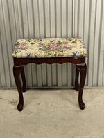 Front view of mahogany bench showing floral upholstered seat and Queen Anne legs