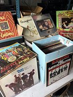 Multiple storage boxes containing numerous vinyl LPs; visible covers Poco "Cantamos", Gladys Knight & The Pips "Imagination", The Beatles "Let It Be", The Kinks "Lola Vs Powerman", Byrds "Preflyte", Dave Clark Five "Glad All Over"