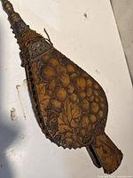 Front of bellows showing grape cluster carving, metal nozzle