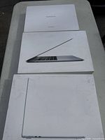 Three Apple laptop boxes laid out flat showing tops