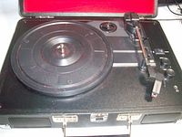 Open suitcase record player showing platter, tonearm and controls