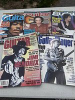 Five guitar magazines laid out showing covers