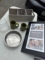 Overall lot showing organizer basket, glass pitcher, two mugs, steamer insert, collage frame