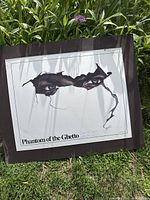 Full view of Phantom of the Ghetto print on brown backing board outdoors