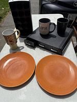 Group shot showing all items: plates, mugs, pod holder, desk drawers