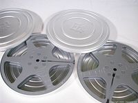 Two Kodak silver metal 8mm film cans with lids removed showing reels
