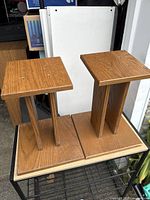 pair of wooden speaker stands on a cart