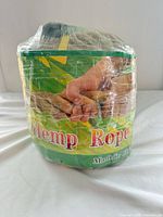 Coiled hemp/jute rope sealed in clear wrap, green label showing name Hemp Rope