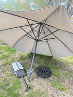 Umbrella open with base and street light on grass