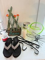 Group shot showing all items: cactus planter, flip flops, watering can, metal hooks, dragonfly tealight holder, candle