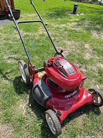 Overall view of Craftsman red push mower on grass