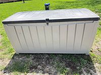 Front view of Keter beige deck box with brown lid, latch centered