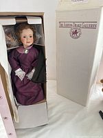 Doll positioned inside original box showing dress, gloves, brooch, boxed condition