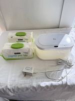 Wipes warmer, two wipes packs and power cord displayed on table