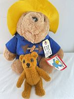 Paddington Bear and small teddy standing together