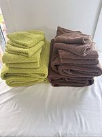 Stacked lime and brown towels on white surface