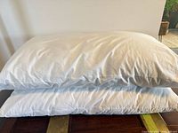 Two stacked white king pillows showing overall condition