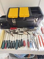 Overall lot showing toolbox, hand tools, clock weight, post toppers