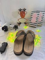 Group shot of all items: sandals, water pump, cords, cactus lights, frog figurine, napkins