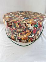 full view of patterned hat box with lid and rope handle