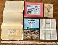 All items laid out including folded blueprint, book, brochure, booklet, letter with ruler for scale
