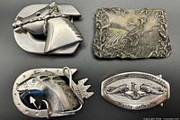 Front view of four belt buckles showing designs